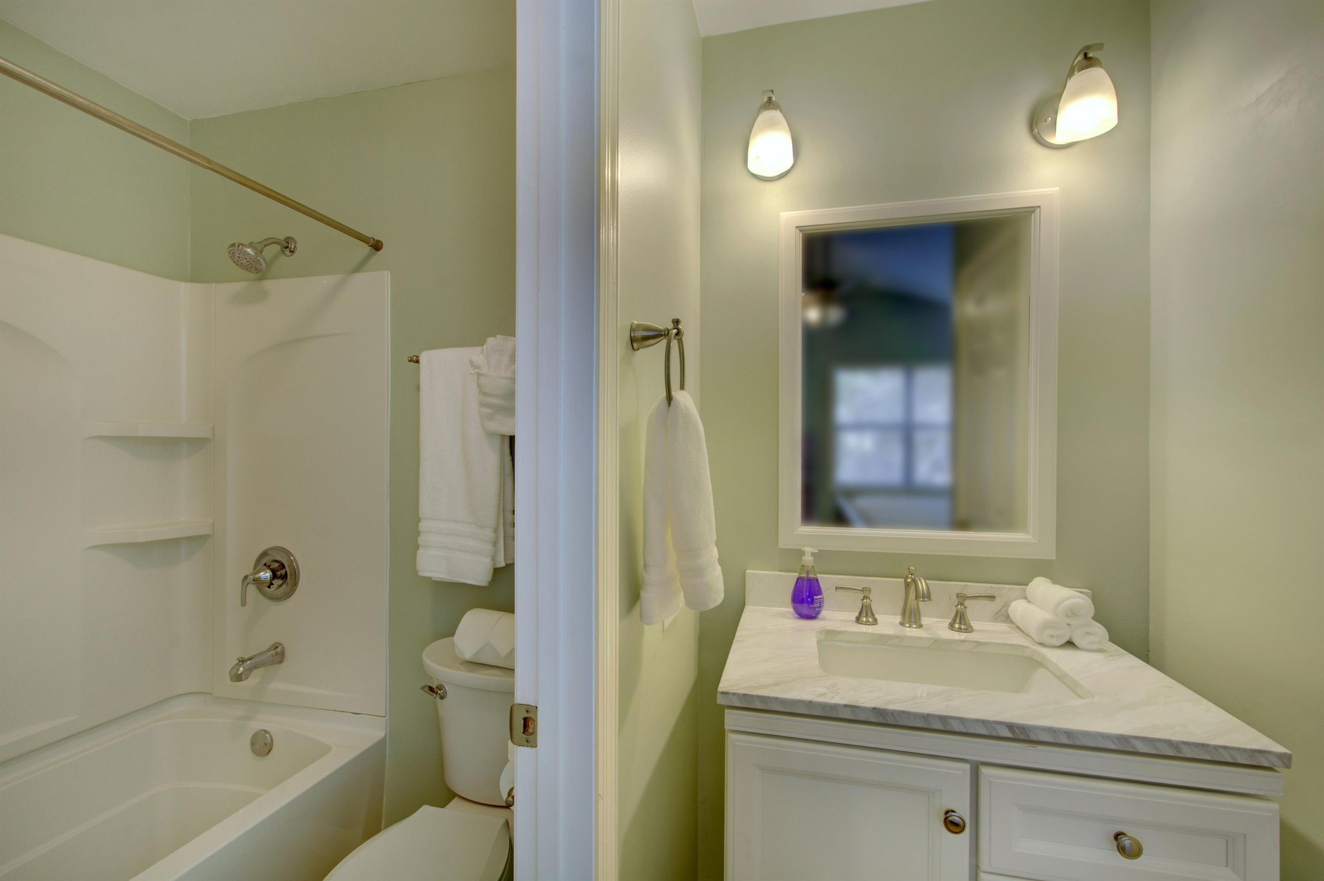 The private en suite bath features a showertub combo, wide vanity, and soft lighting—just steps from the king bedroom for added comfort and convenience.