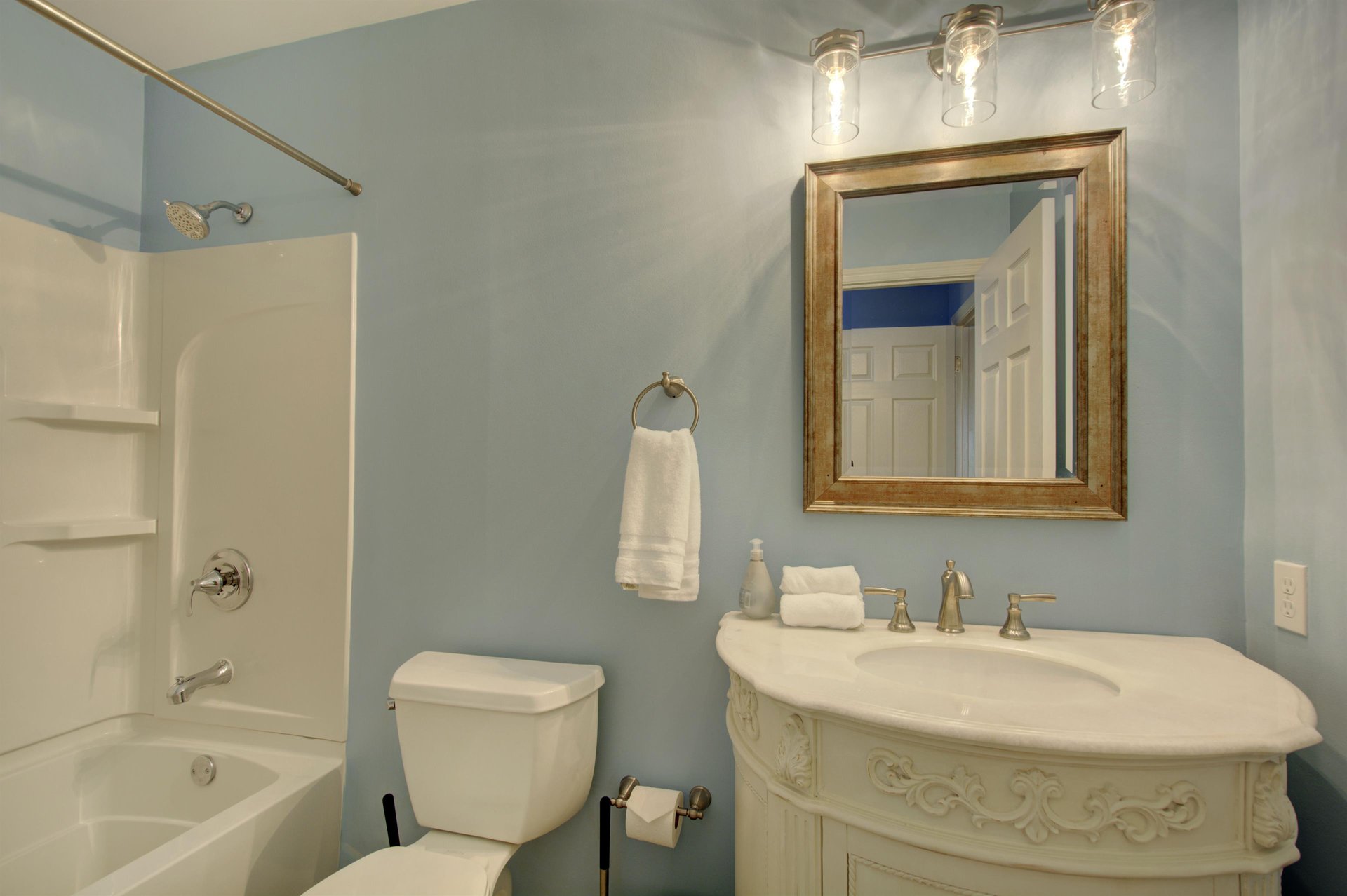This stylish guest bathroom features a showertub combo and elegant vanity—perfect for freshening up after a day exploring the Village or lounging by the pool.