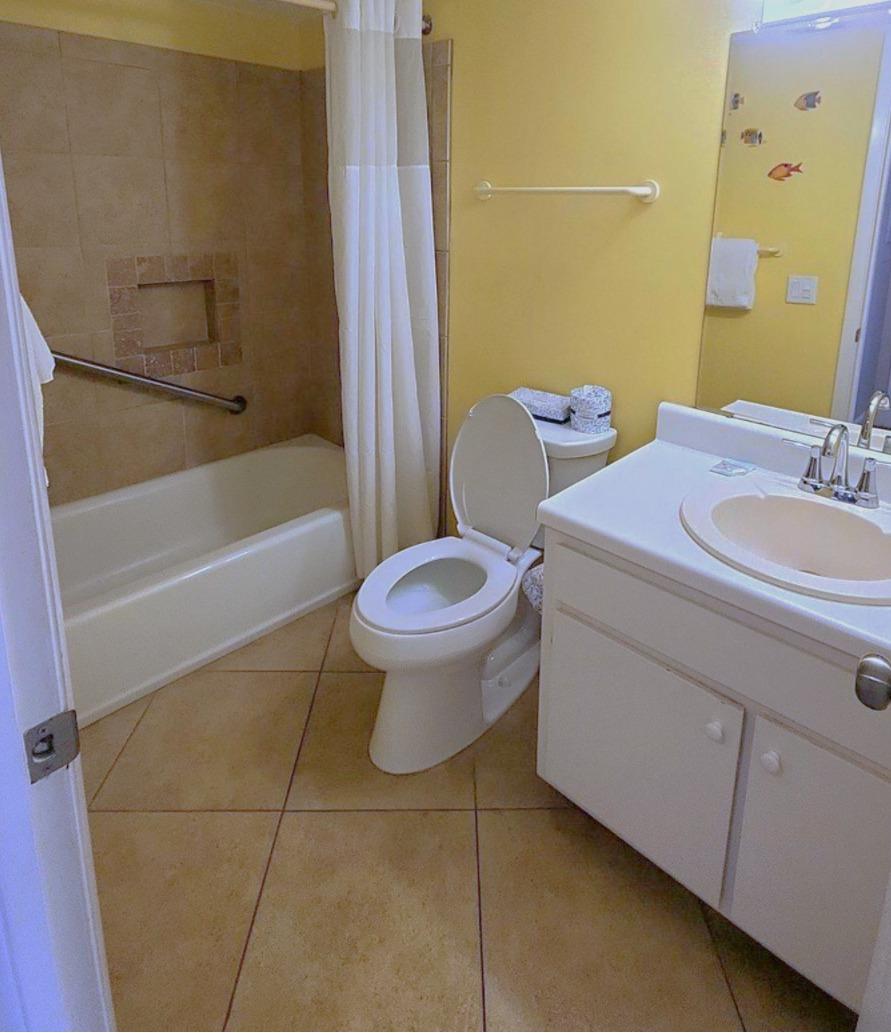 The guest bathroom features a tiled tub and shower combination with a clean, functional layout and easy access from the main living area.