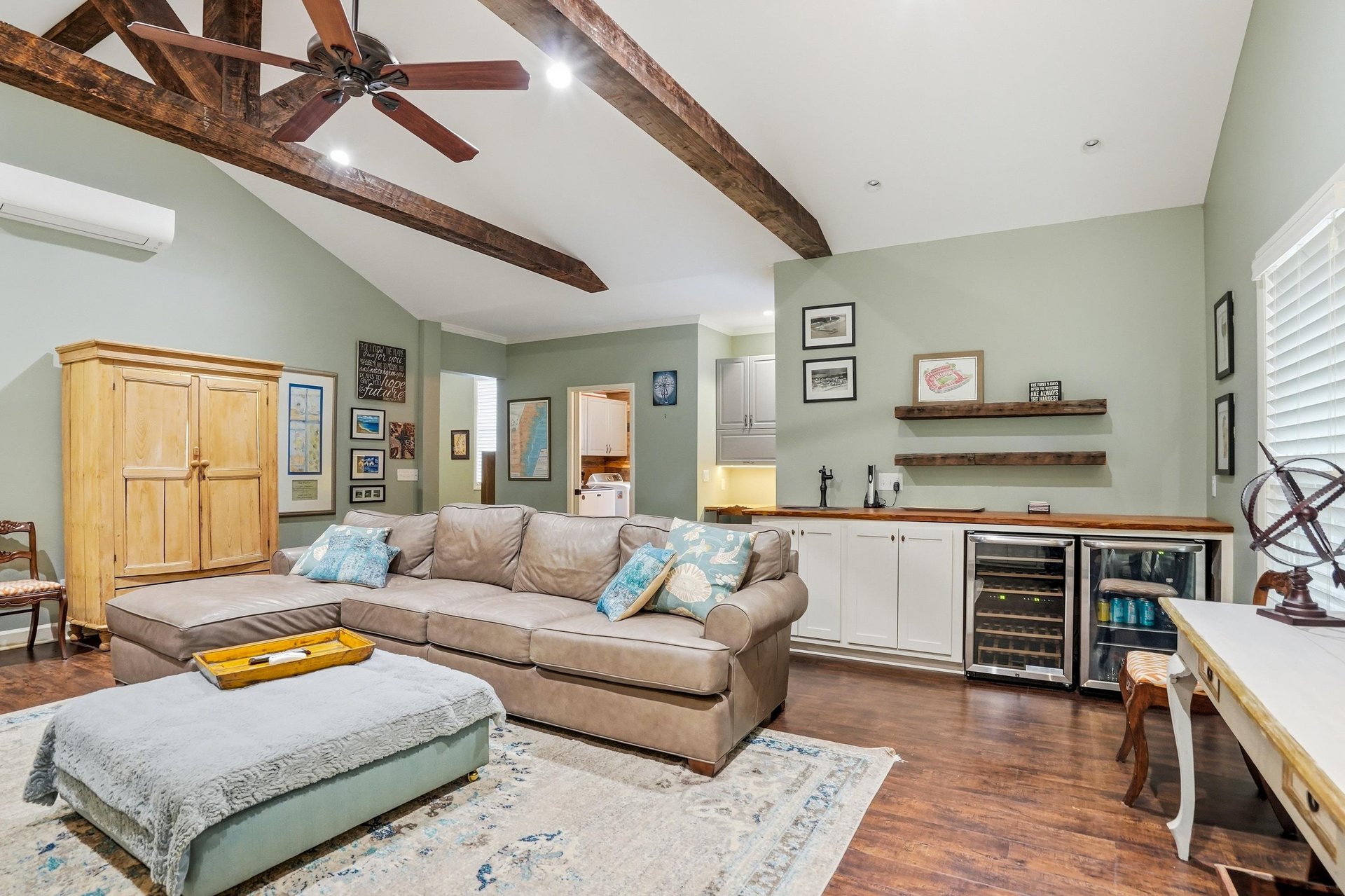 The dens wet bar and wine fridge tucked into the back — the conversation never has to stop.