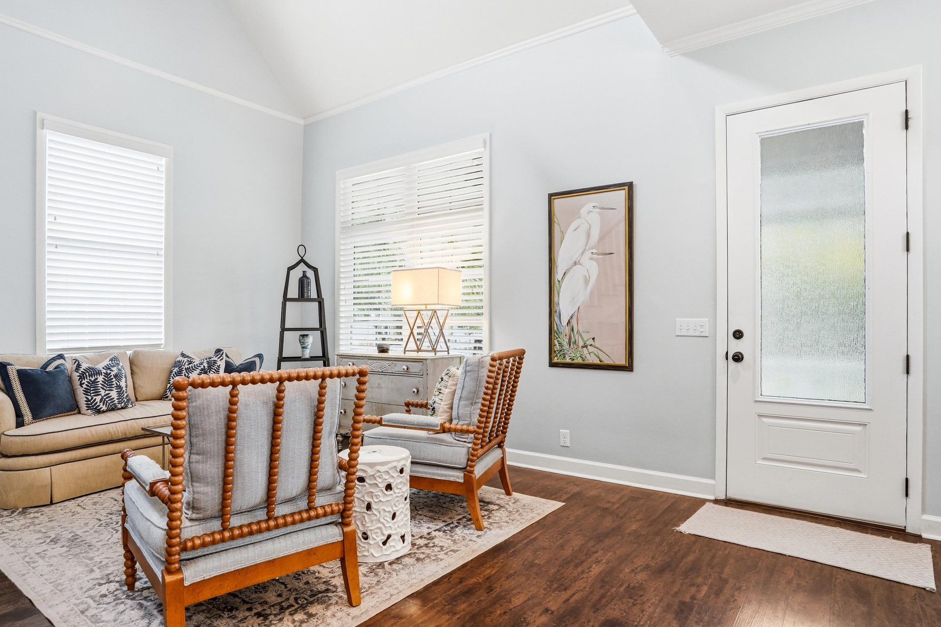 Dark hardwood floors and a welcoming foyer with accent seating and a builtin bookshelf — an arrival that already feels like home.