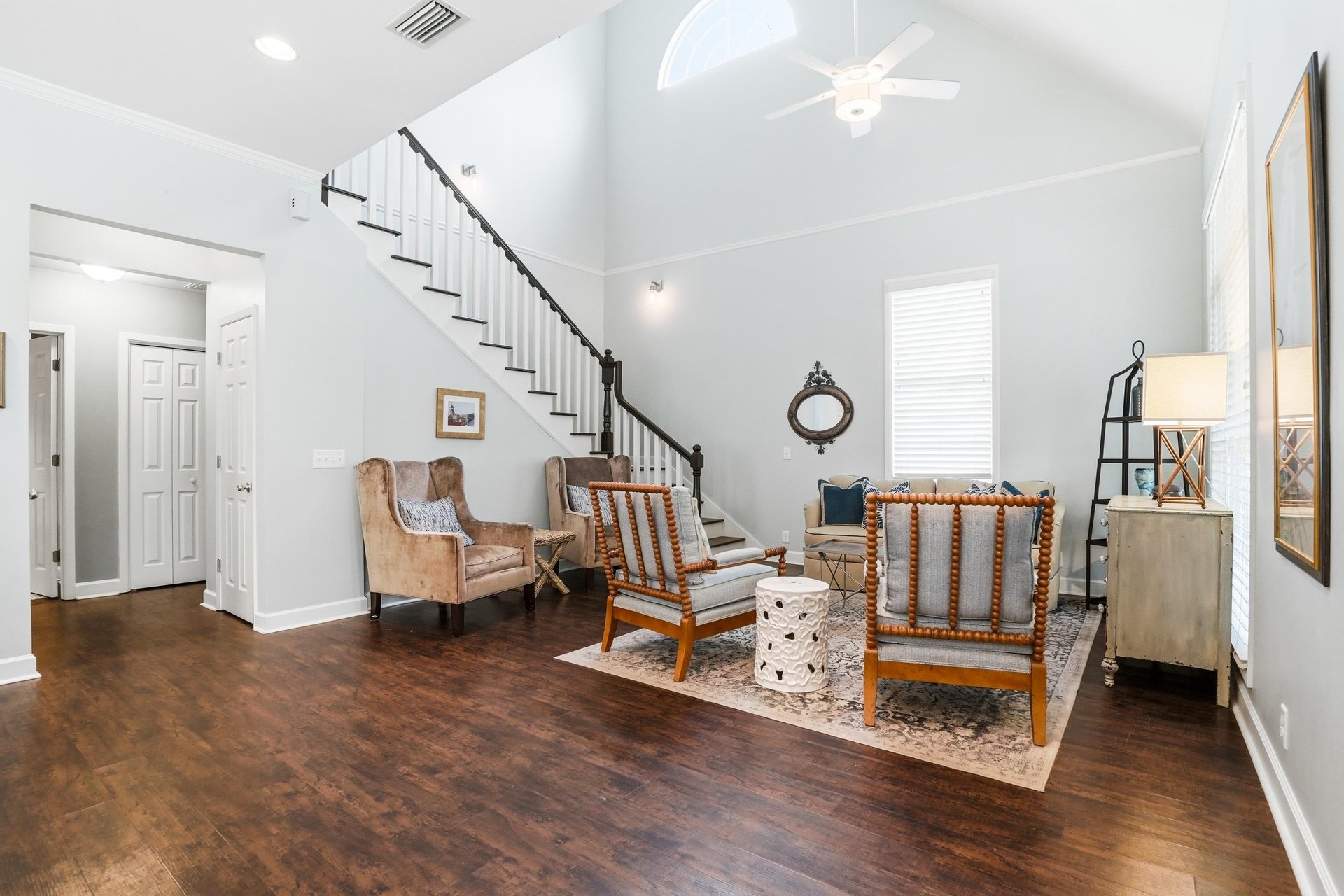 Soaring ceilings, an open ironrail staircase, and the first glimpse of the homes expansive main level.