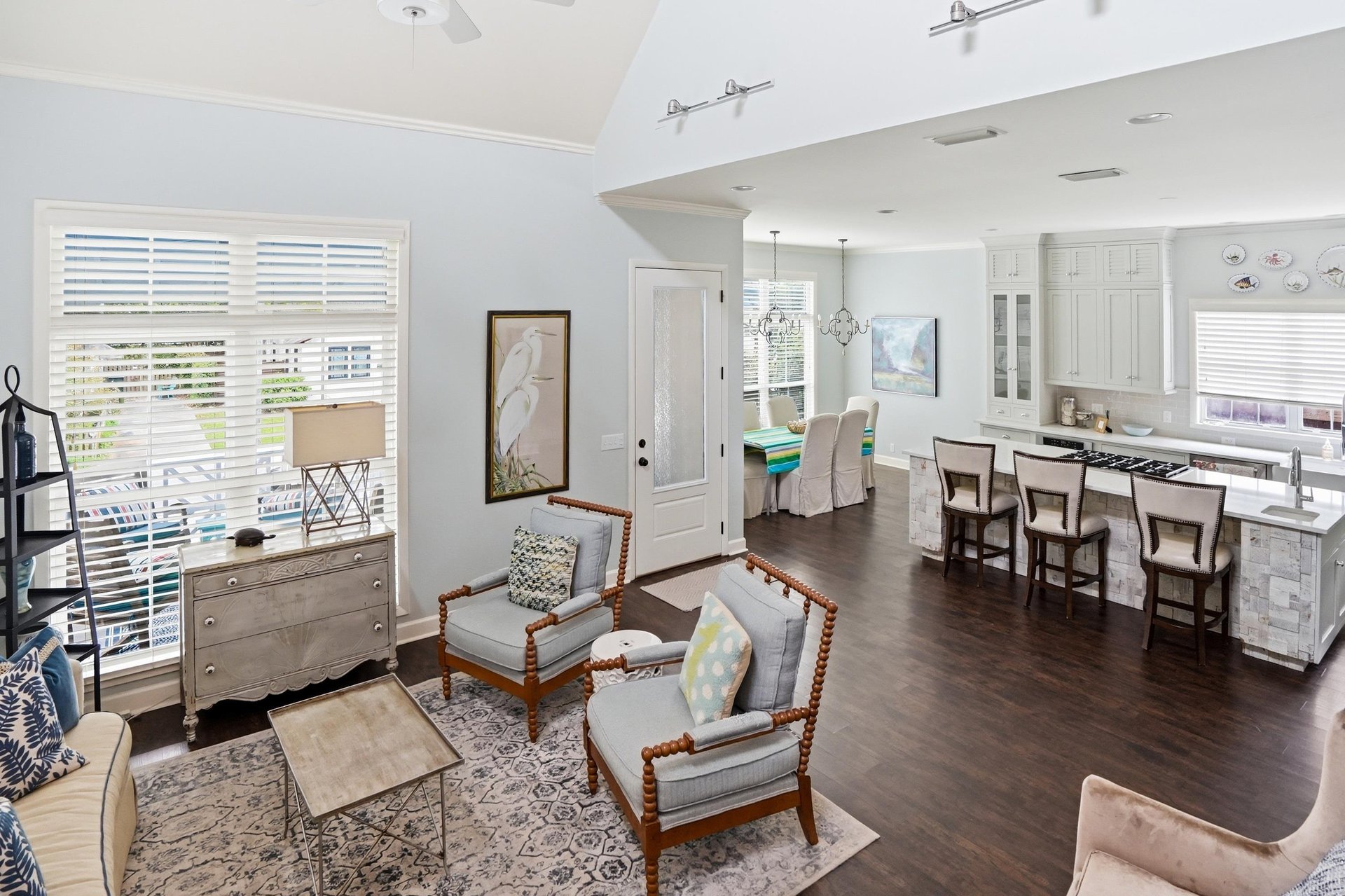 The full openconcept flow from living room through dining into the kitchen — all on rich dark hardwood floors.