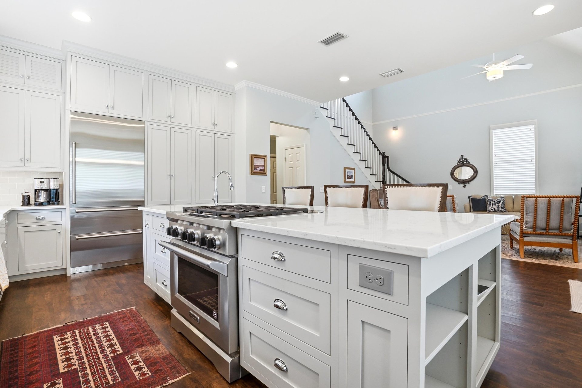 The island with pendant lighting and the staircase beyond — the whole main level visible from one vantage point.
