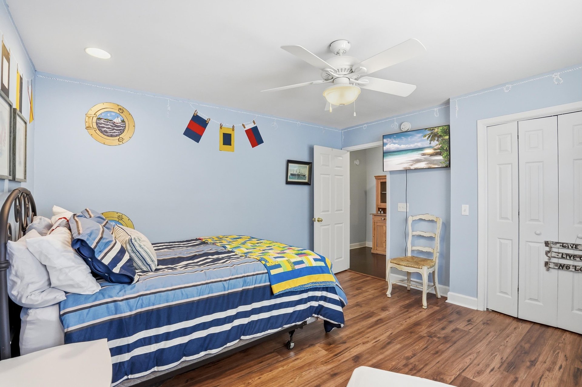 Wider view with closet doors and anchor art — every corner of this room stayed on brief.