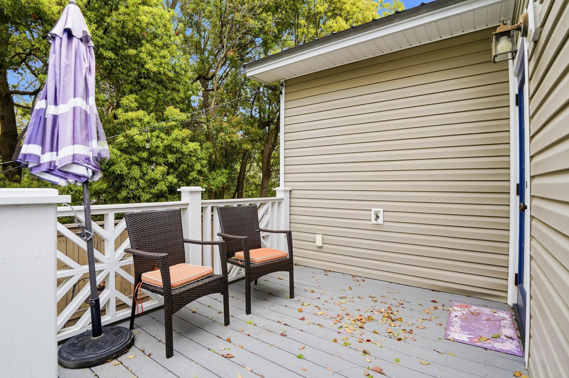 A shaded back deck with outdoor seating and a canopy of mature trees — where the afternoon goes once you decide to stay put.