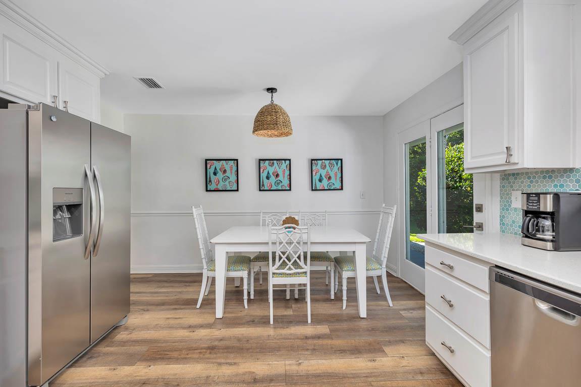 Main house dining area at 530 Delegal showing a dining table and seating, with windows providing natural light.