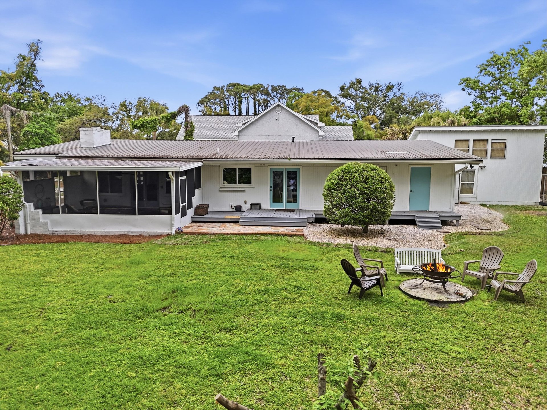 Backyard view of 530 Delegal showing the fire pit, seating, and open lawn area.