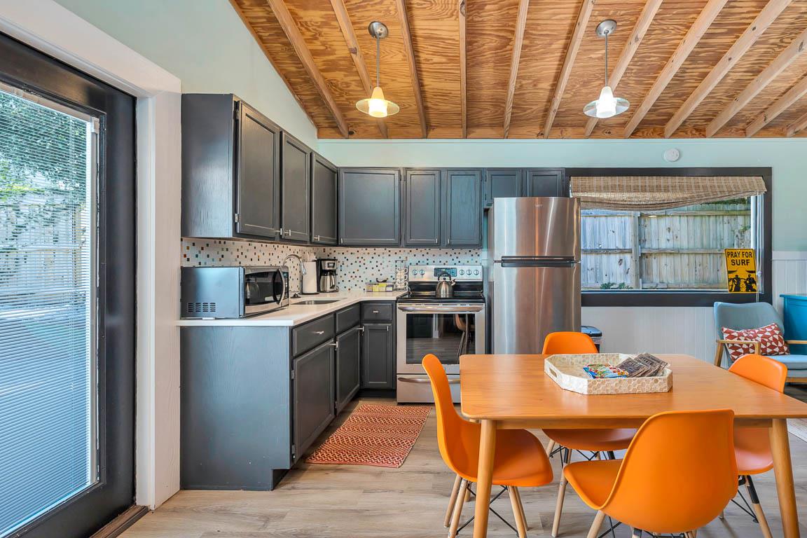 Guest house kitchen and dining area at 530 Delegal featuring a full kitchen, dining table, and direct access to the pool courtyard on St. Simons Island.