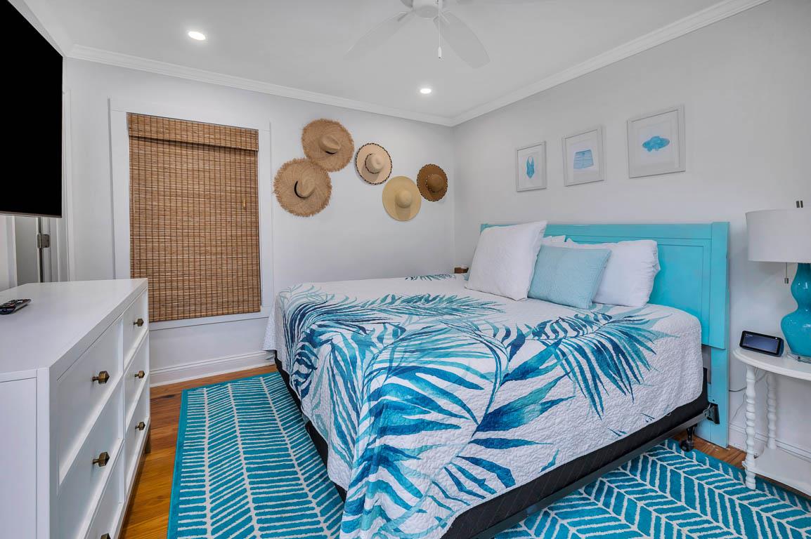 Primary bedroom at 530 Delegal showing a king bed, large wallmounted television, bedside tables, and coordinated furnishings.