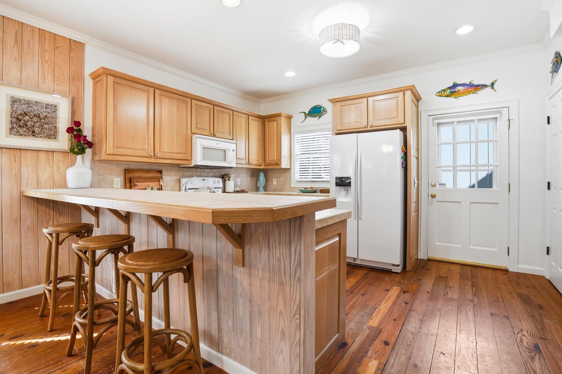 Additional kitchen angle showing the breakfast bar, rear entry, and prep space along the main work zone.