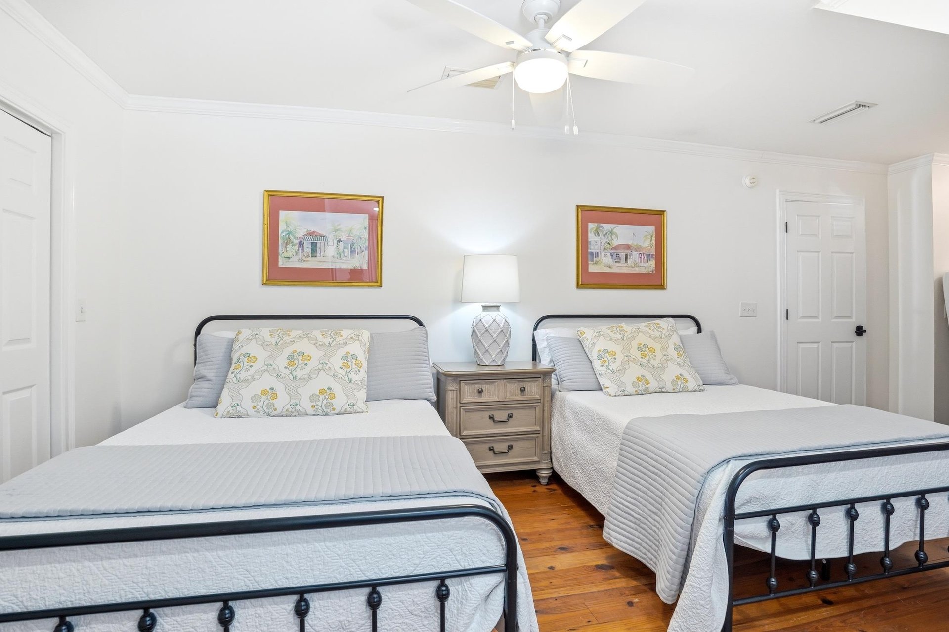 Upstairs bedroom with two double beds and hardwood floors, part of the upperlevel bedroom wing.