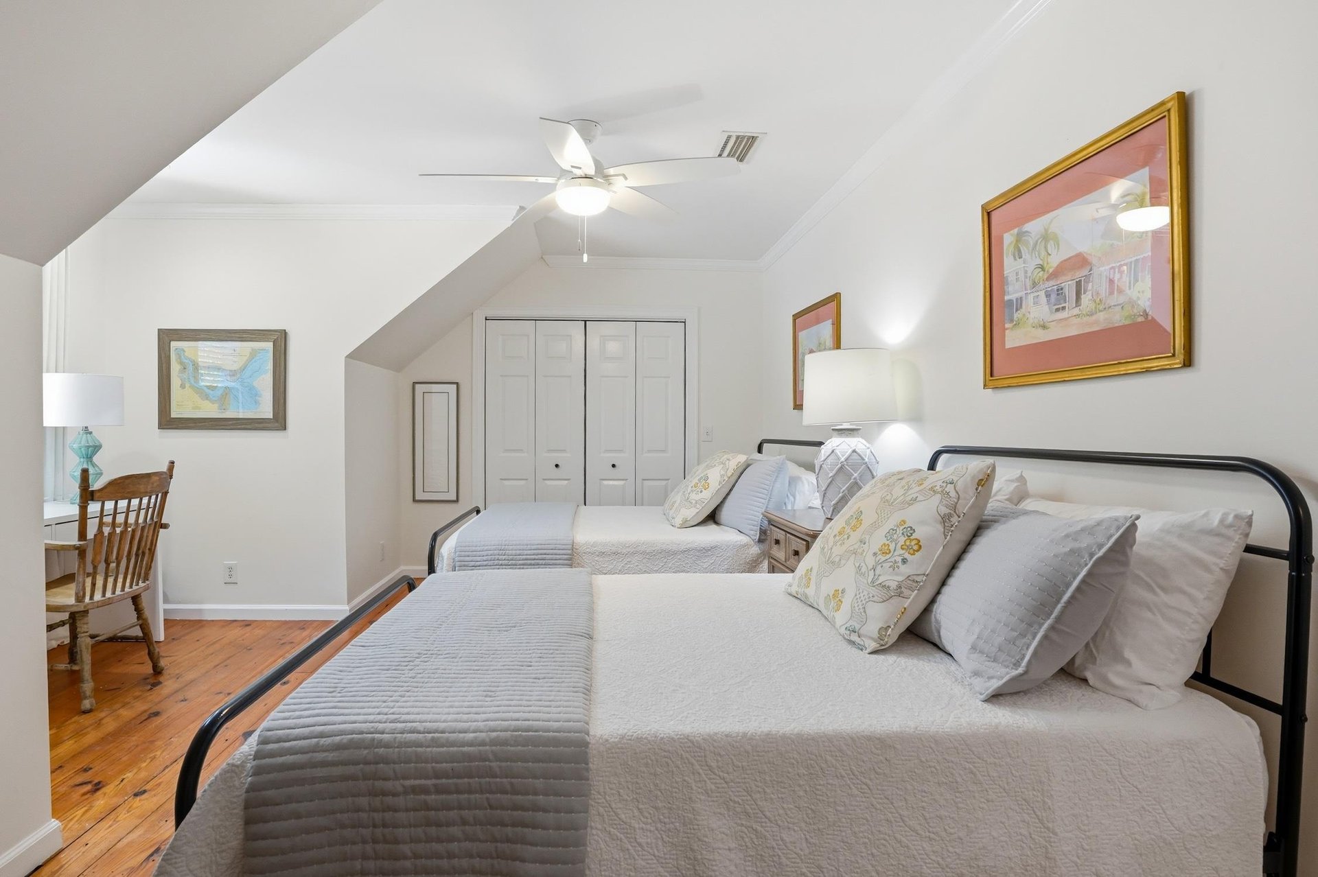 Alternate angle of the upstairs twodouble bedroom showing the desk area, vaulted ceiling lines, and ensuite access.