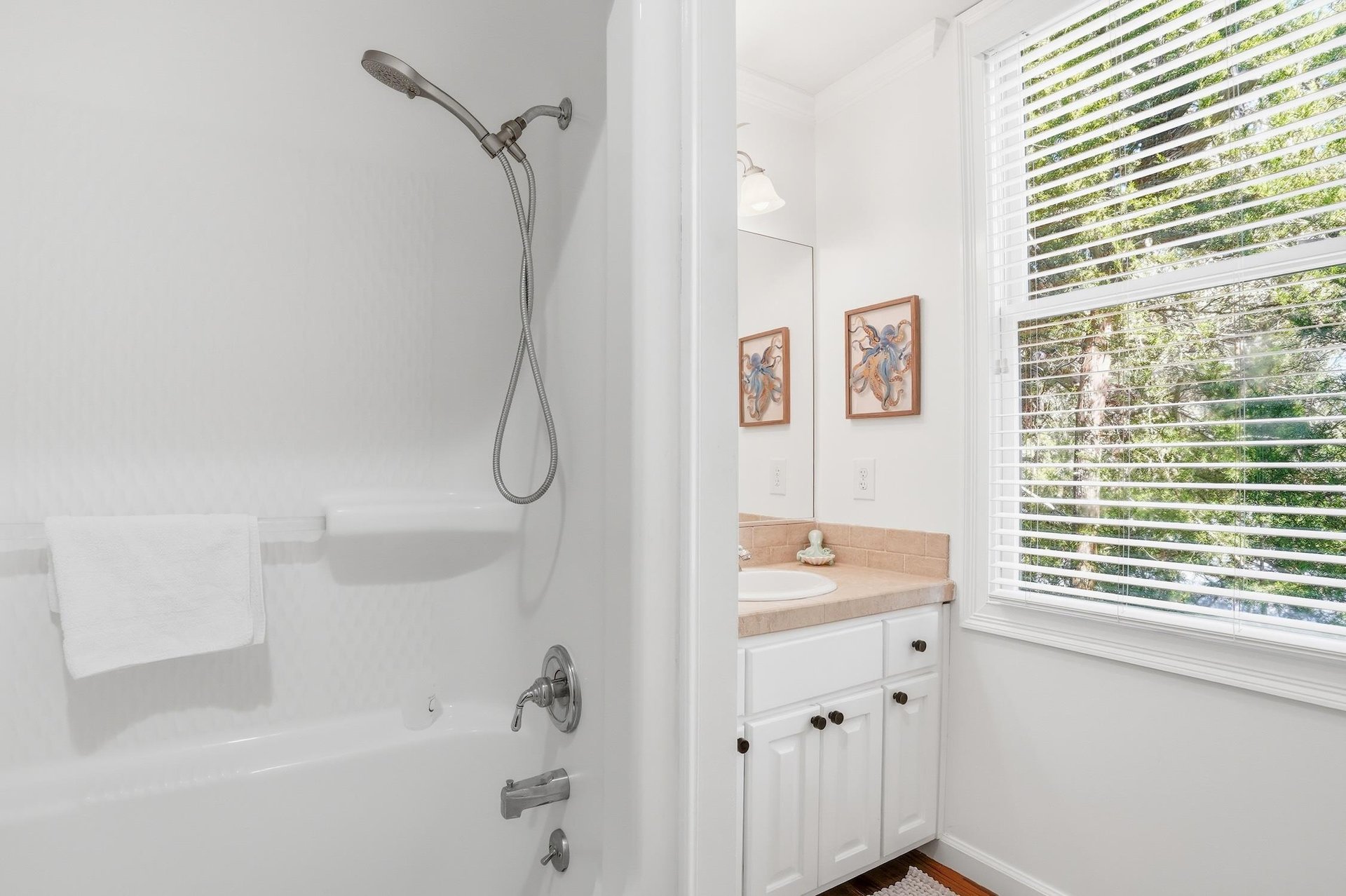 Ensuite bathroom connected to the upstairs twodouble bedroom with vanity, window, and tubshower combination.