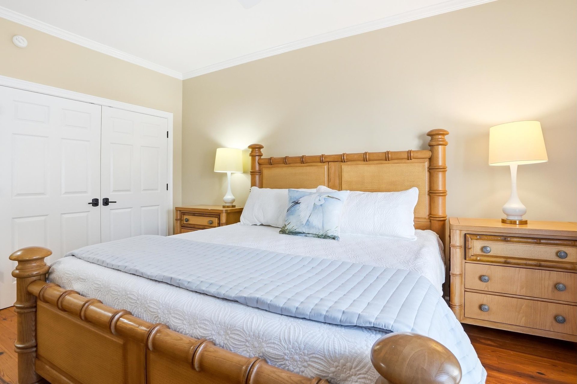 Alternate angle of the main floor king primary suite showing bedside storage and the room layout.