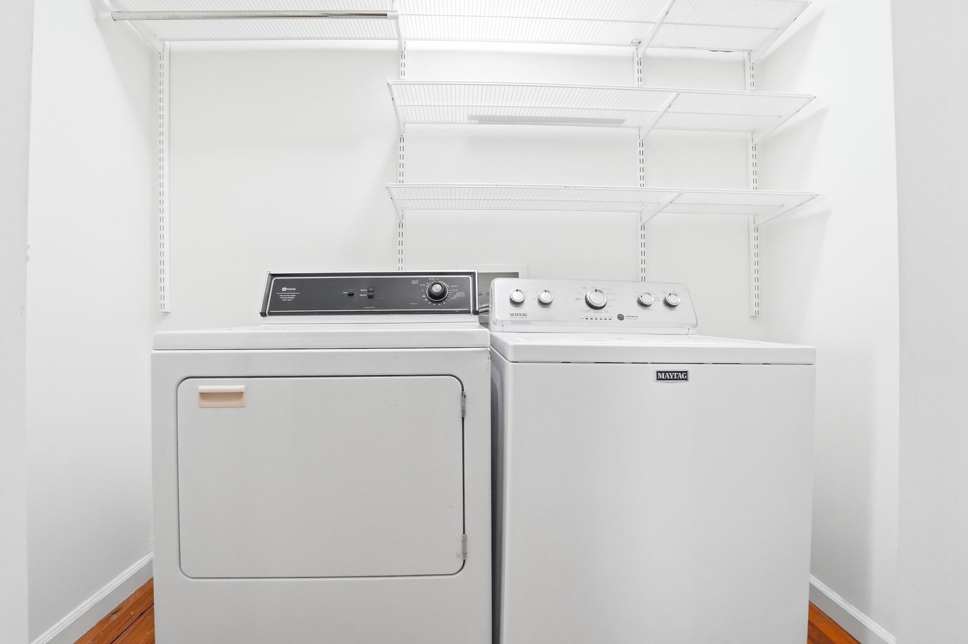 Fullsize washer and dryer inside the home with shelving above for longer stays.