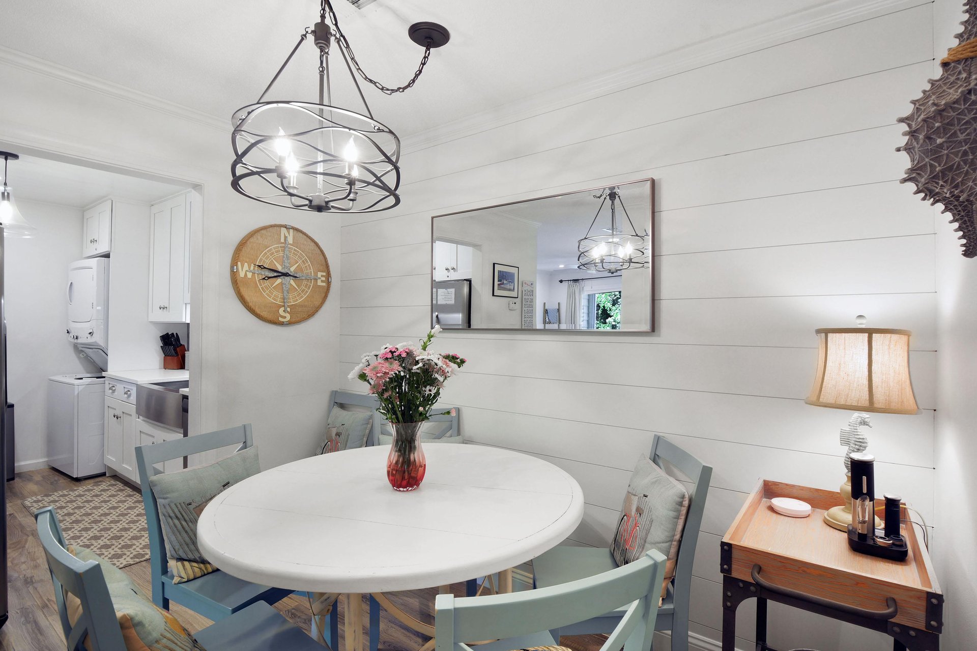 Round dining table beside the living room, with shiplap walls and natural light.