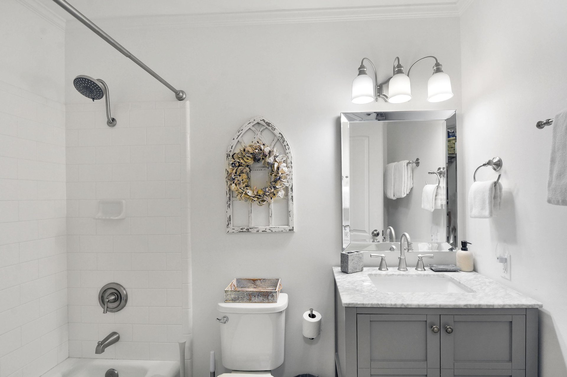 Bathroom with tubshower combination, marblestyle vanity, and bright lighting.