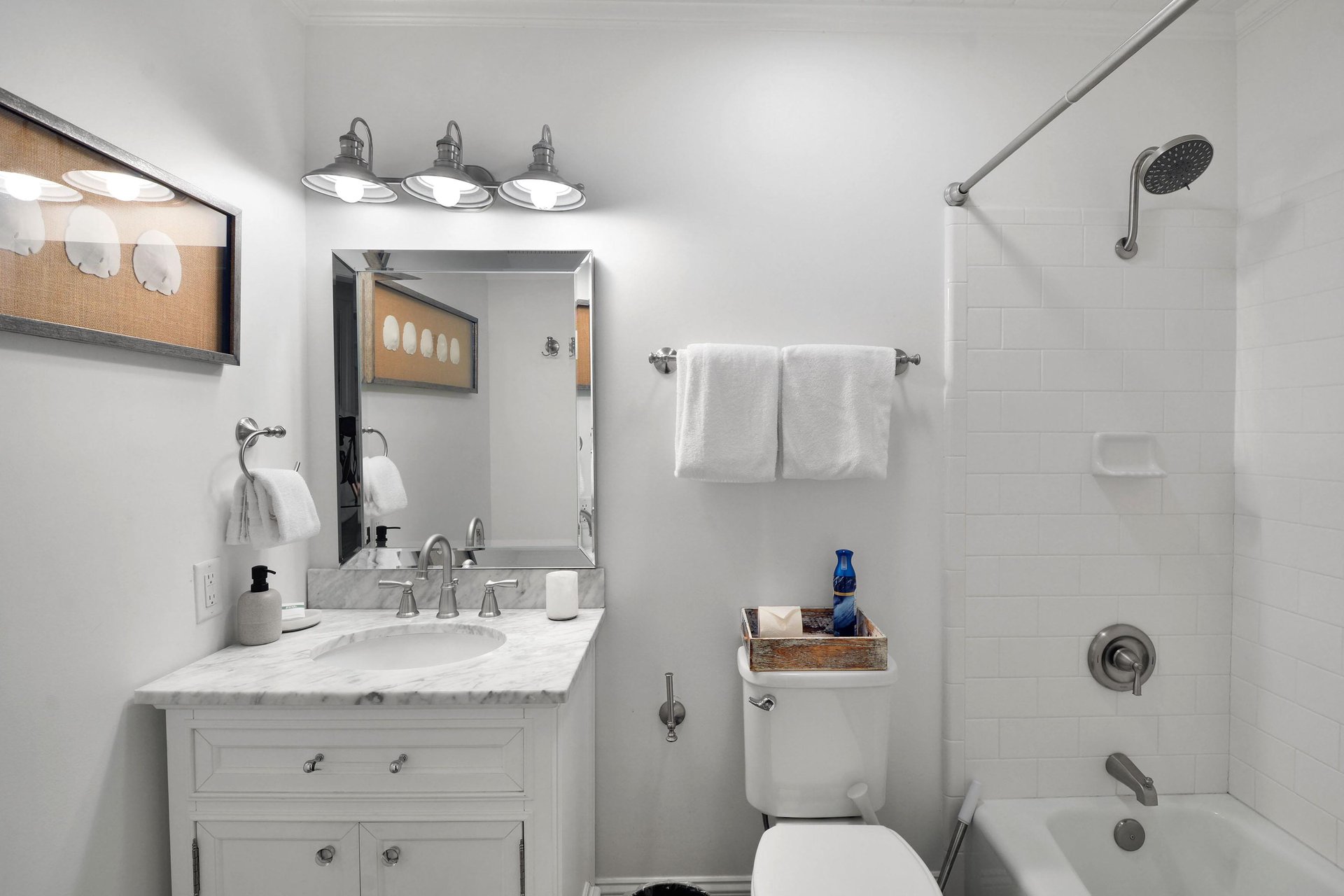 Bathroom with vanity storage, bright lighting, and a tubshower combination.