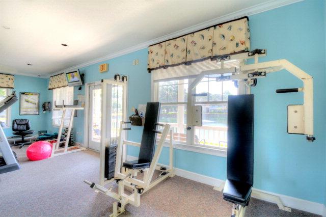 Fitness room with strength machines, mirrors, and open workout space.