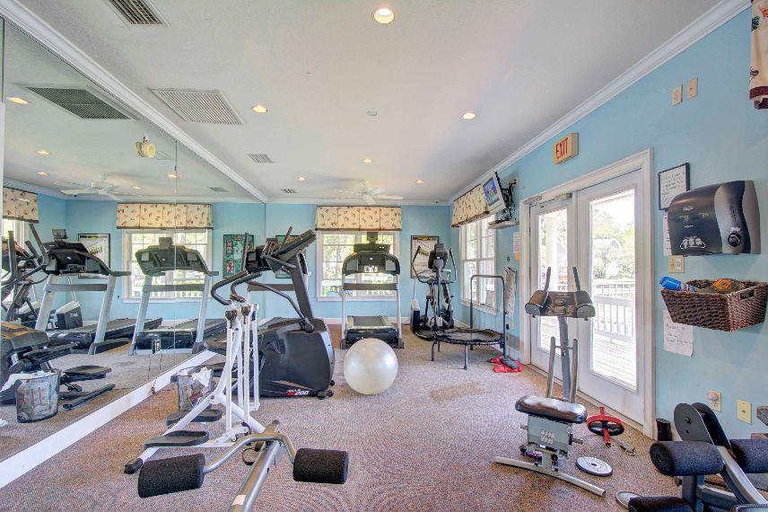 Fitness room with cardio machines, free weights, and room for stretching.