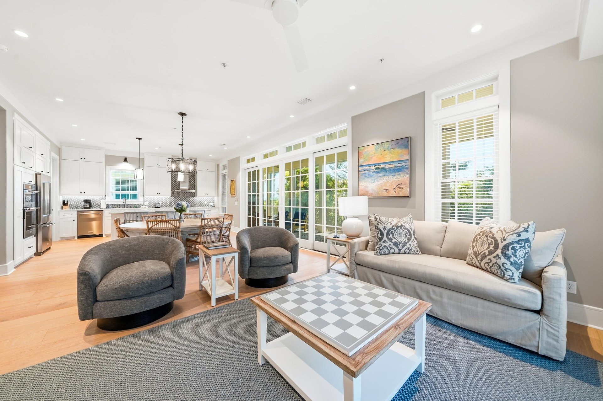 French doors and tall windows bring natural light into the central gathering space of this Jekyll Island vacation home.