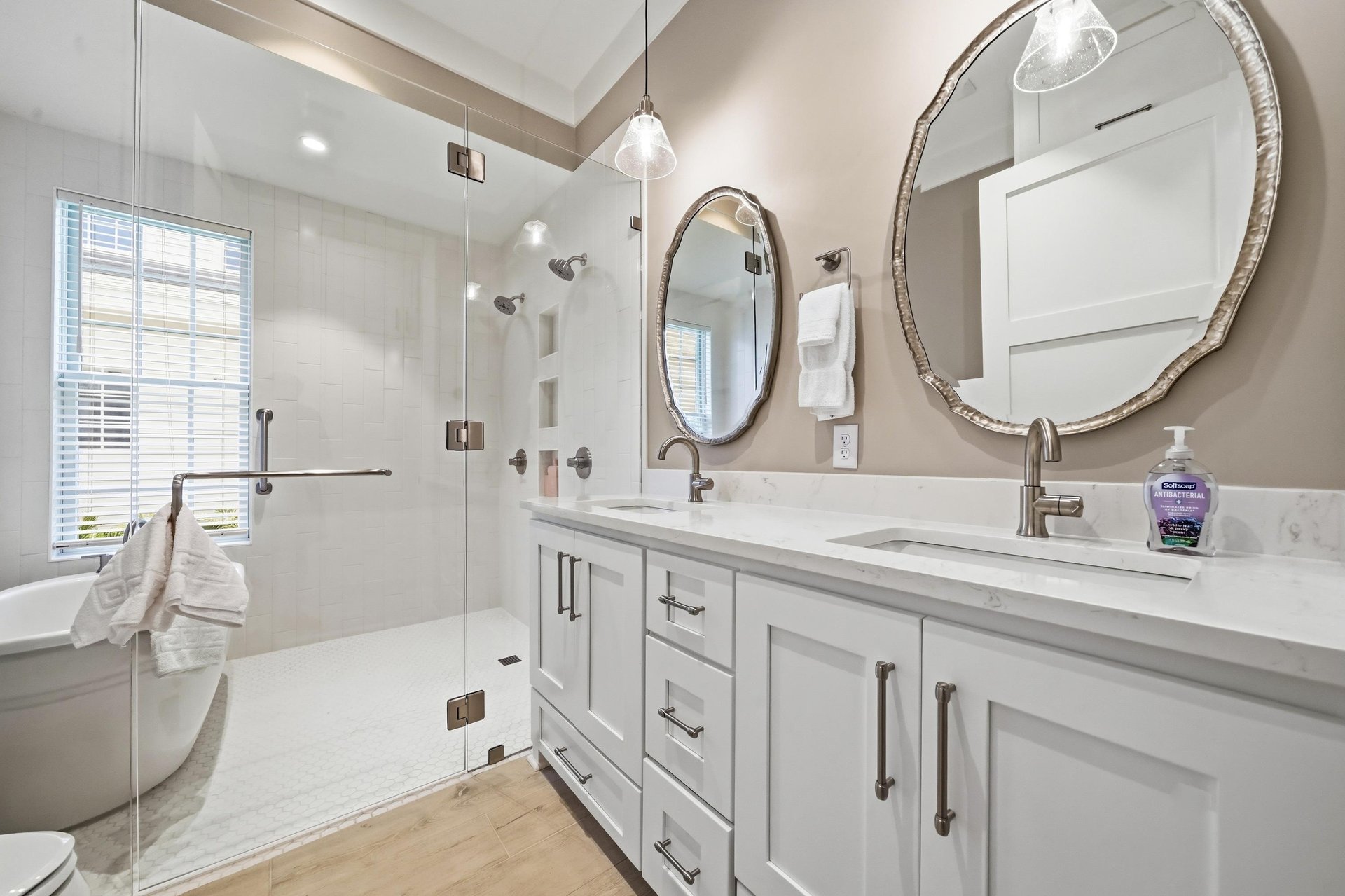 The complete bath gives the mainfloor king suite two sinks, a freestanding tub and a glass walkin shower.