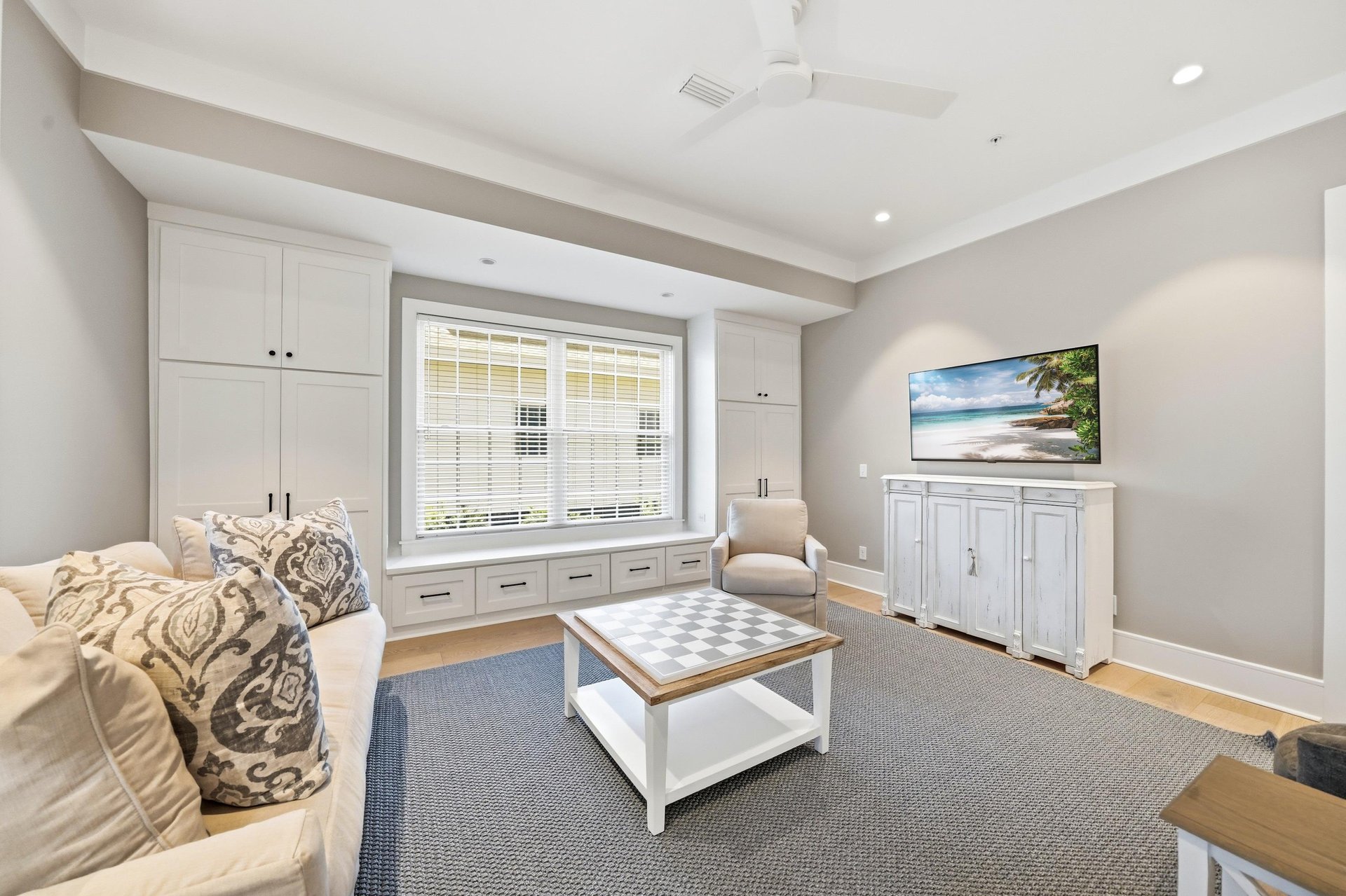 A second livingroom angle highlights the window seat, storage and easy connection to the dining area.