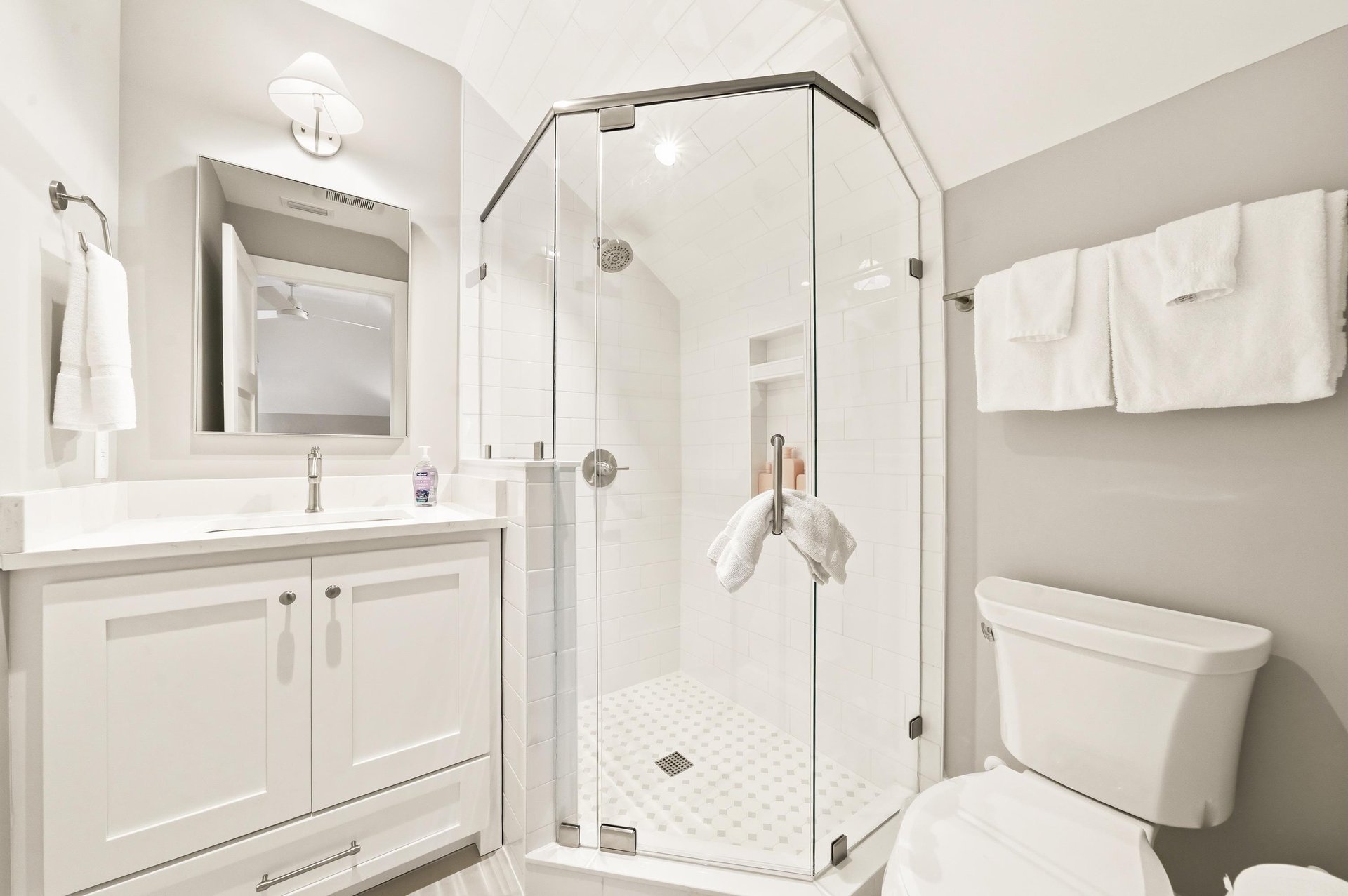 A glass shower, vanity storage and bright tile serve the second queen bedroom and bunk room.