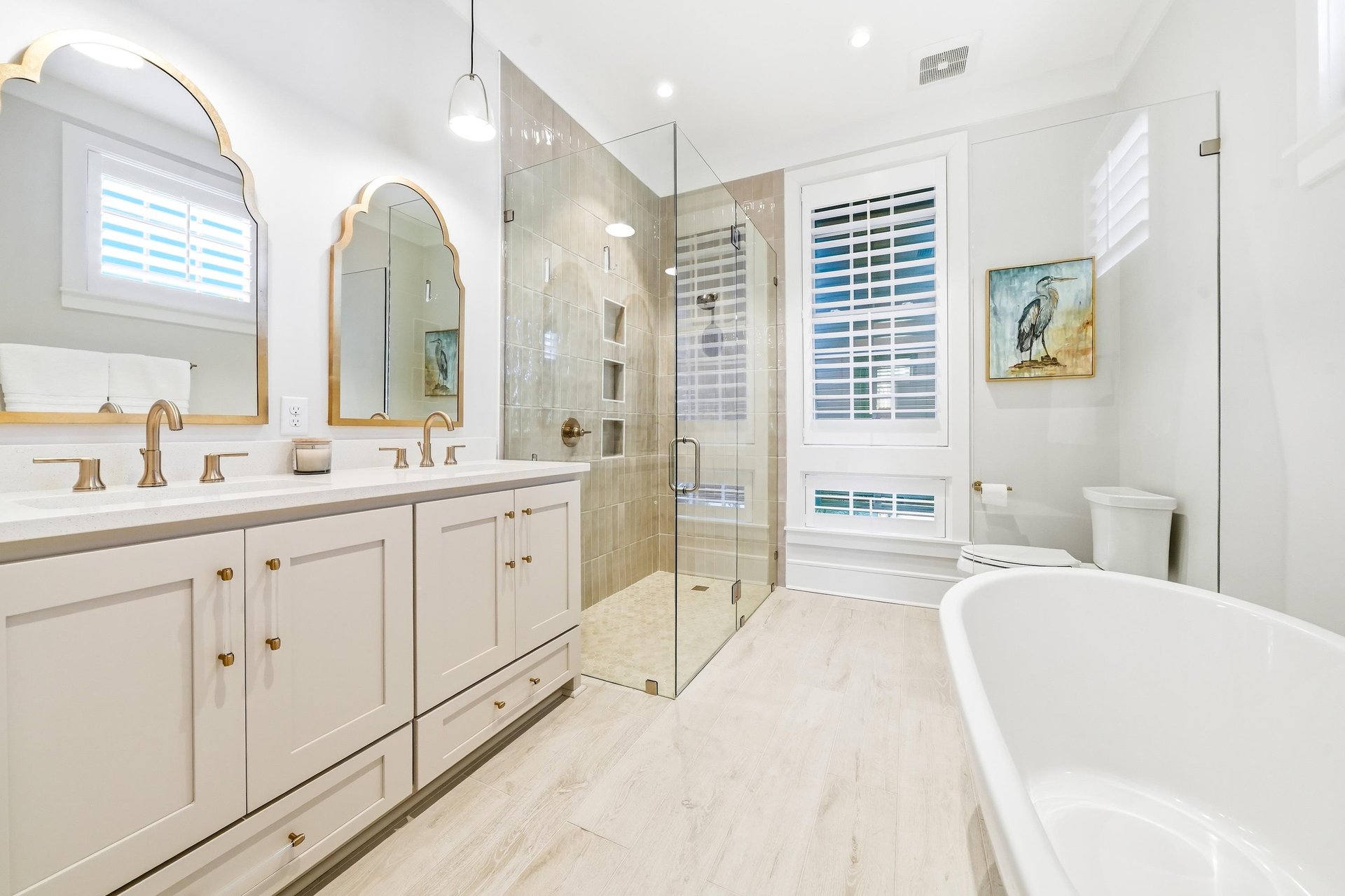 A freestanding bath and separate glass shower adjoin the downstairs primary bedroom.