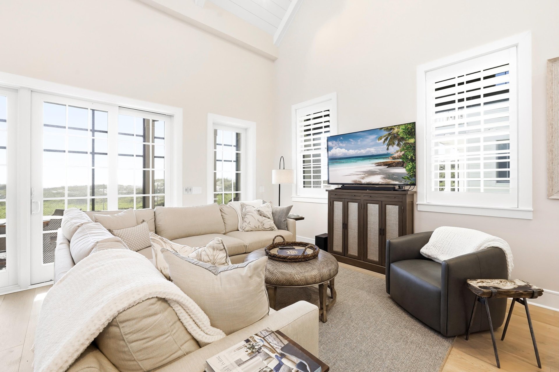 The sectional faces the television, with the dunes beyond the glass doors.