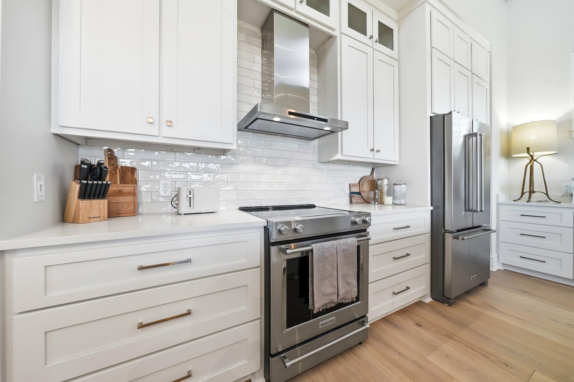 A smooth cooktop, vent hood and adjacent counters anchor the cooking area.