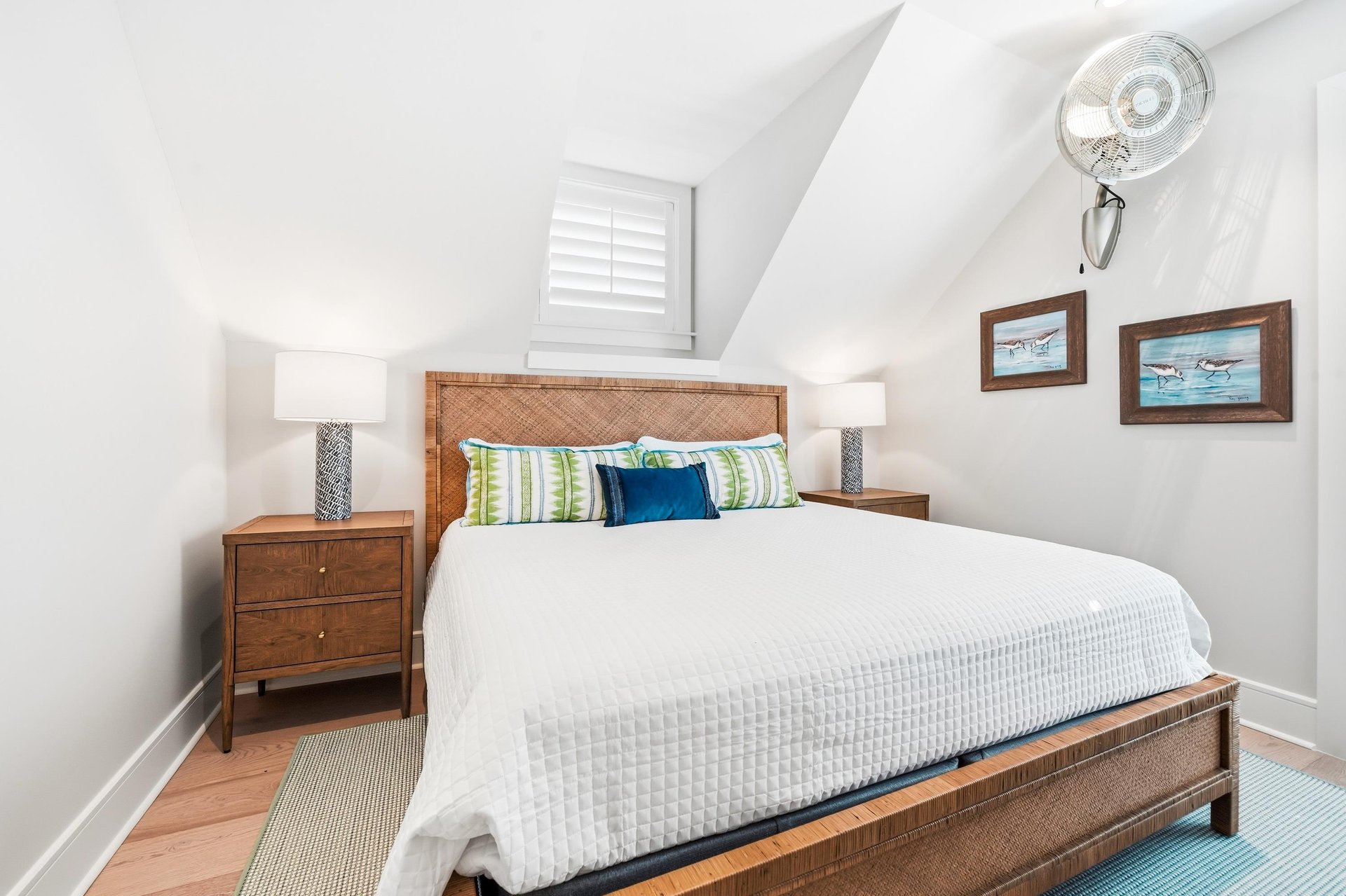 A woven headboard and greenandblue accents warm the wooden furnishings.