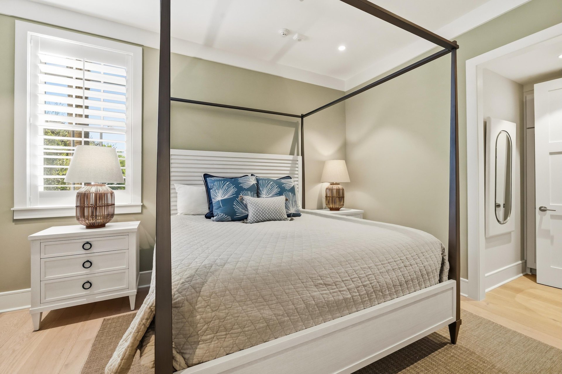 Blue accents and shuttered windows complement the sagegreen walls.