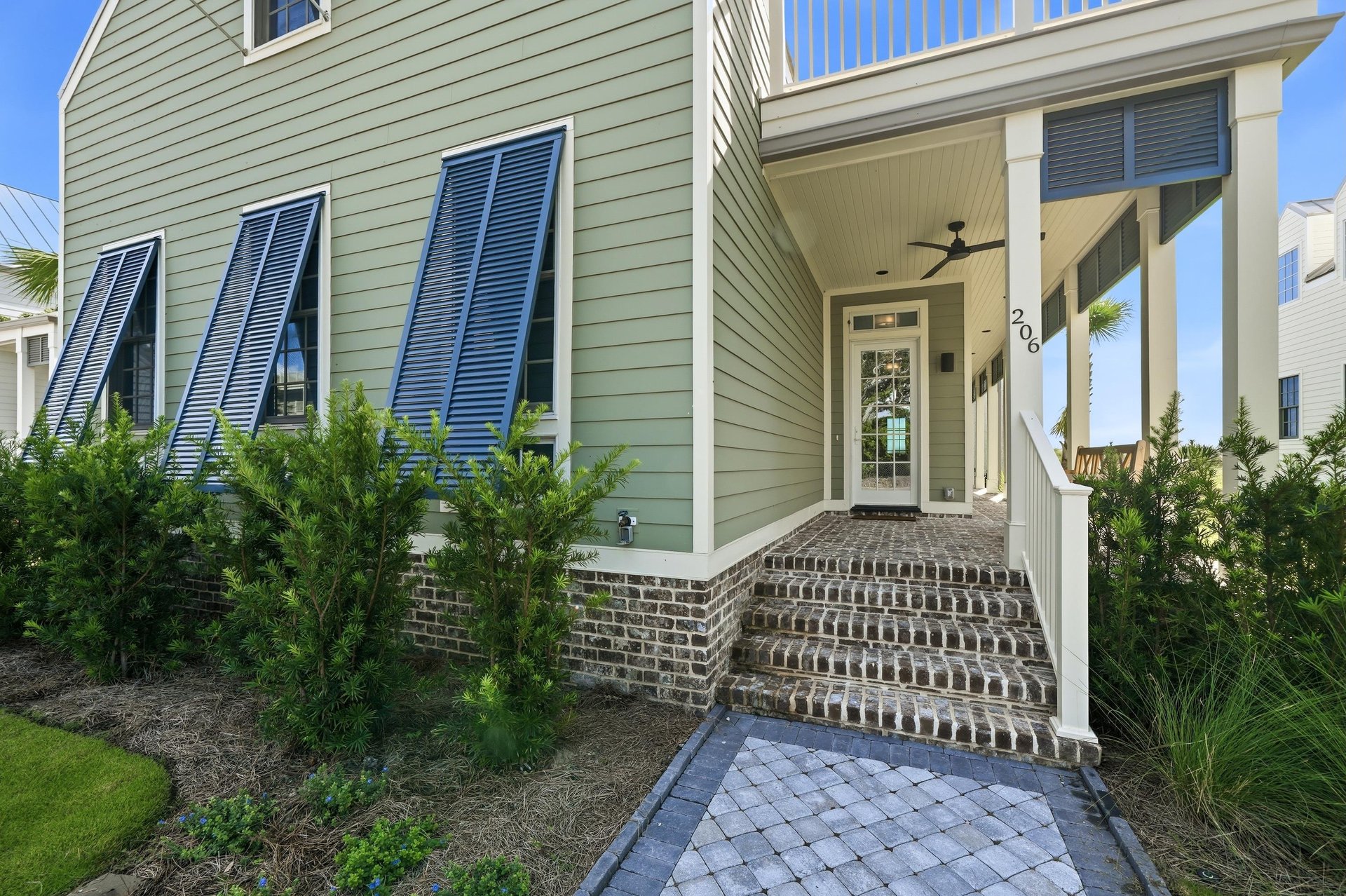 A shaded porch leads to the front door at 206 Live Oak Way.
