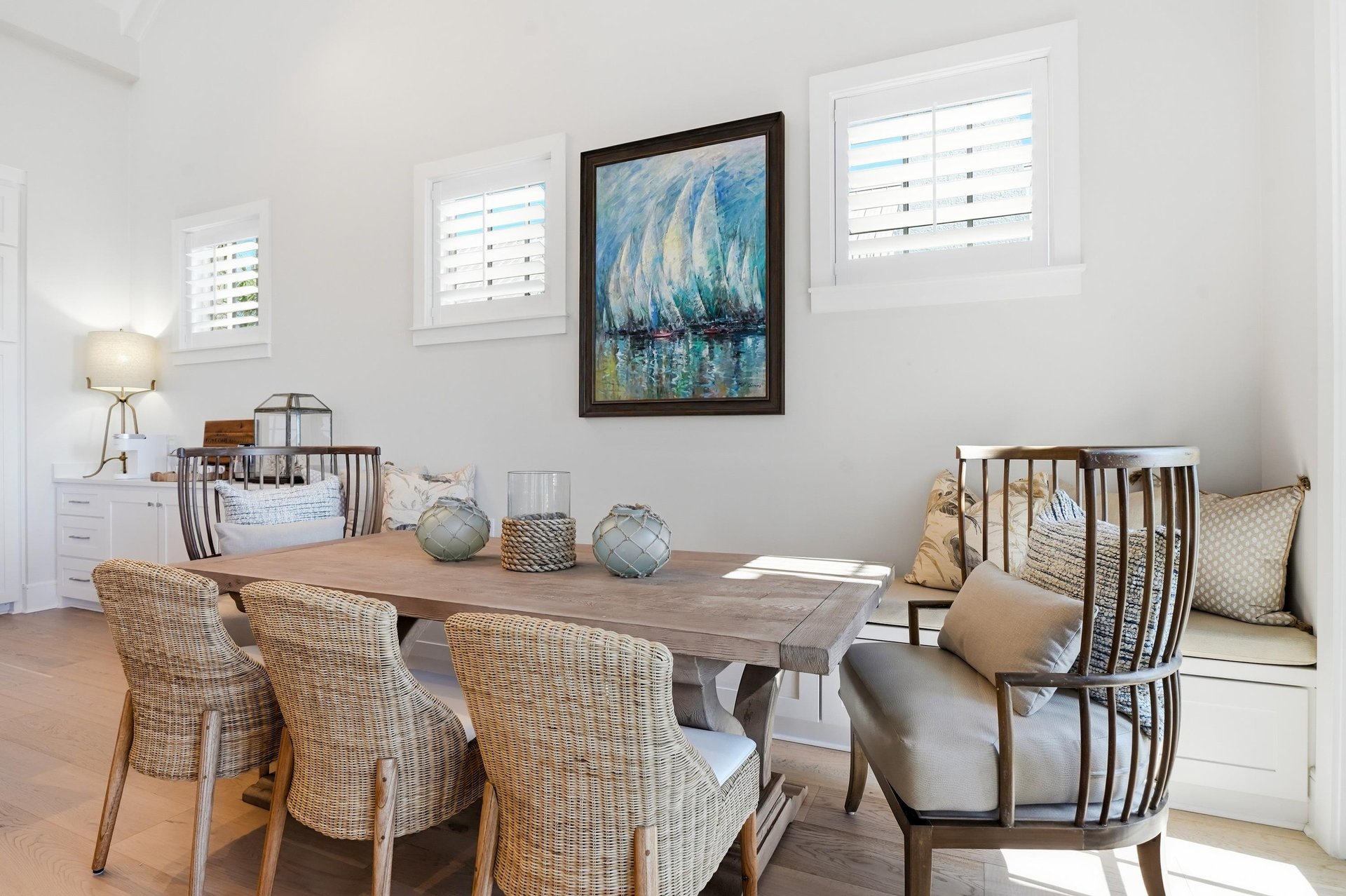 Woven chairs and a builtin bench provide seating beside the living area.