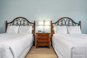 Nightstand table with bedside lamps, alarm clock and a phone