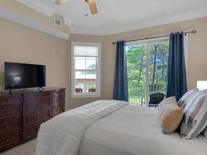 Primary bedroom with TV and balcony access