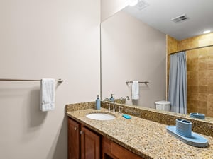 Spacious bathroom features granite countertops, warm wood cabinetry, and thoughtful amenities to start each morning refreshed and relaxed.