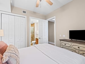 Unwind in your serene bedroom featuring a plush Queen bed, ceiling fan for comfort, and convenient ensuite bathroom access.