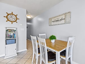 The dining space welcomes with warm wood tones and charming coastal décor