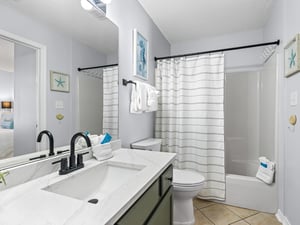 The coastalthemed bathroom features a spacious tubshower combo