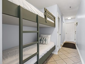 The familys bunk bed nook offers cozy sleeping for kids, complete with soft linens and nautical touches in this tiled hallway entry.
