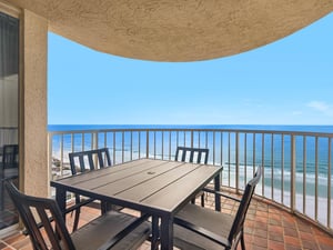Savor your morning coffee at this oceanfront dining table, where endless blue waters stretch to the horizon from your private balcony retreat.