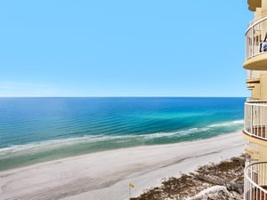 Stunning beachfront view from this highrise property, showcasing pristine white sand and turquoise waters stretching to the horizon.