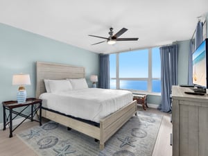 Wake up to endless ocean views from your comfortable bed, where soft coastal hues and gentle ceiling fan create the perfect beachside retreat.