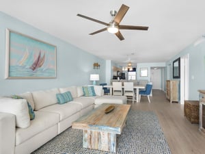 Relax in your coastalthemed living space with plush seating, nautical artwork, and an open layout flowing seamlessly into the dining area.