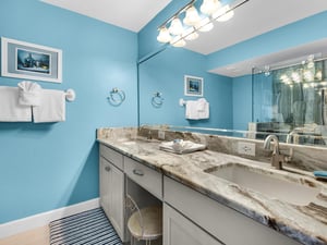 Refresh in your elegant bathroom with marble countertops, dual sinks, and cheerful blue walls that brighten every morning routine.