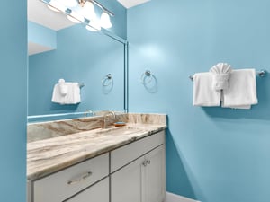 Your private bathroom features a stunning marble vanity and soothing blue walls, creating a spalike atmosphere for your morning routine.