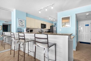 Your bright coastal kitchen invites you to gather at the breakfast bar, where oceanthemed touches make every meal feel like vacation.